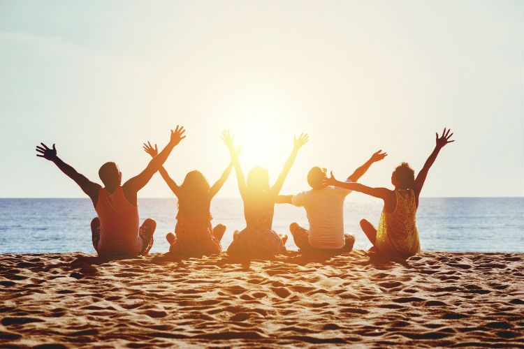 Freunde am Strand bei Sonnenuntergang