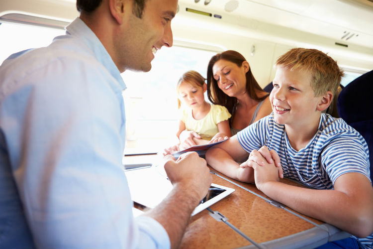 Familie im Zugbeschäftigen sich mit Tablets