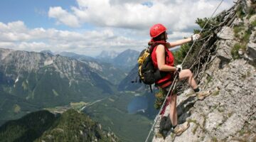 Person die an Felswand klettert