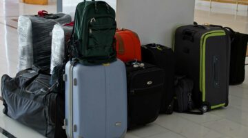 Mehrere Reisetaschen und Koffer stehen auf dem Boden