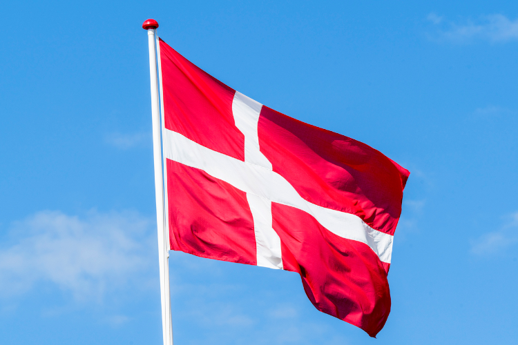Eine Flagge von Dänemark vor blauem Himmel
