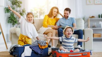 Familie sitzt im Wohnzimmer und freut sich auf den Urlaub