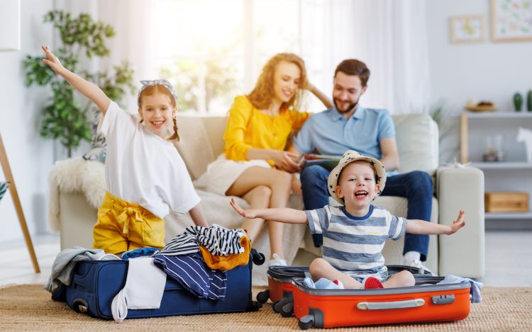 Familie sitzt im Wohnzimmer und freut sich auf den Urlaub