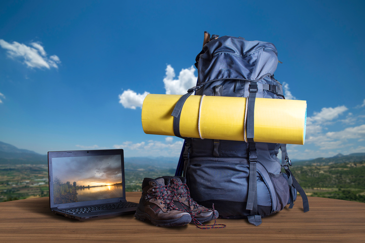 Rucksack, Schuhe und Laptop stehen auf einen Tisch