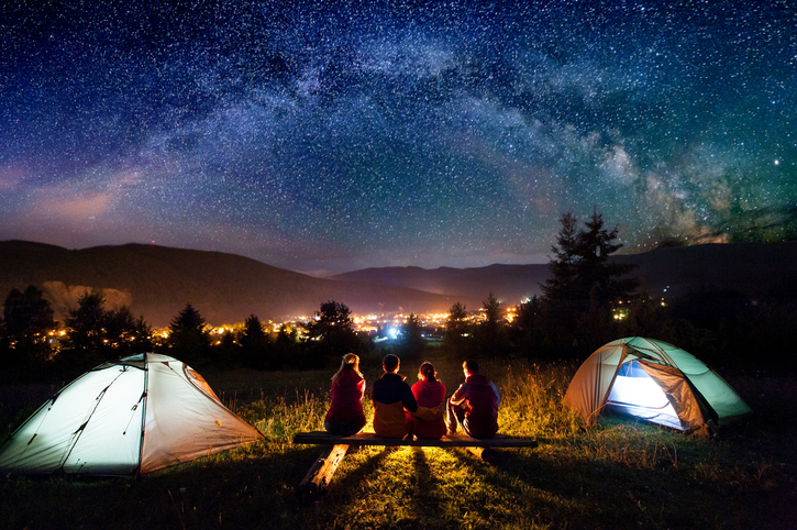 Zwei Zelte und Camper unter Nachthimmel