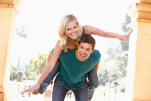 Young Man Giving Woman Piggyback Outdoors