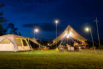 Night camping atmosphere. It is a low-light night shot with noise and grain. Long exposure photography causes moving parts to blur. There will be sharpness only at the selected focus point.