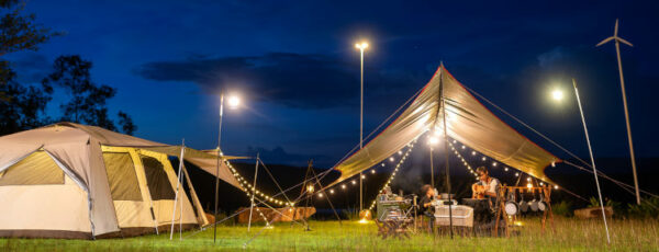 Night camping atmosphere. It is a low-light night shot with noise and grain. Long exposure photography causes moving parts to blur. There will be sharpness only at the selected focus point.