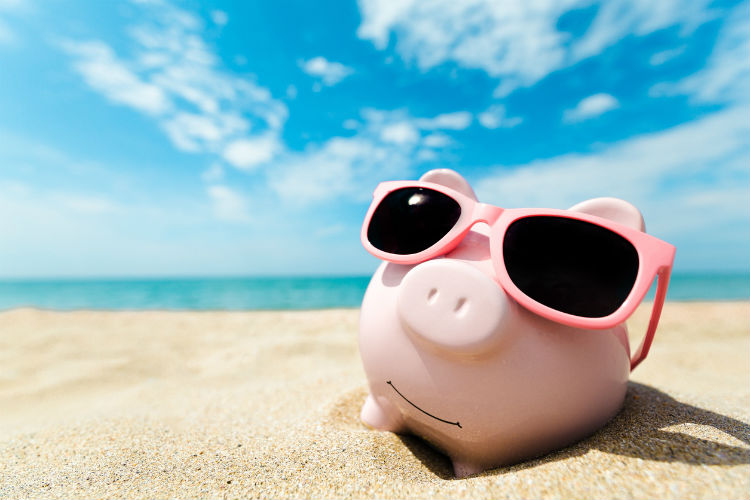 Reisen Supermarkt - Sparschwein am Strand mit Sonnenbrille auf