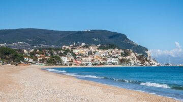 Sandstrand am Meer mit Berg im Hintergrund